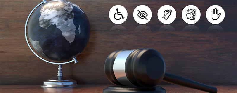 Gavel and globe on desk with disability icons representing accessibility and inclusion in law and justice.