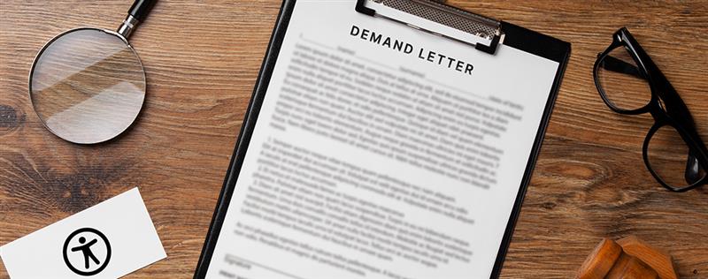 Demand letter on a clipboard with a magnifying glass and accessibility symbol, highlighting ADA compliance concerns.