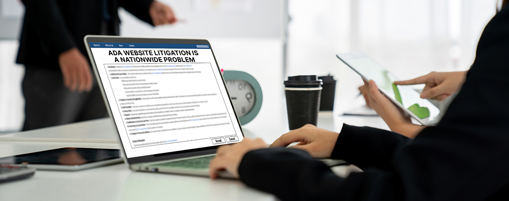 Person working on a laptop displaying ADA website litigation information, with coffee cup and tablet in view.