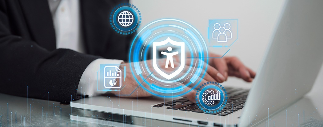 Business professional working on laptop with accessibility shield, highlighting ADA website compliance strategy