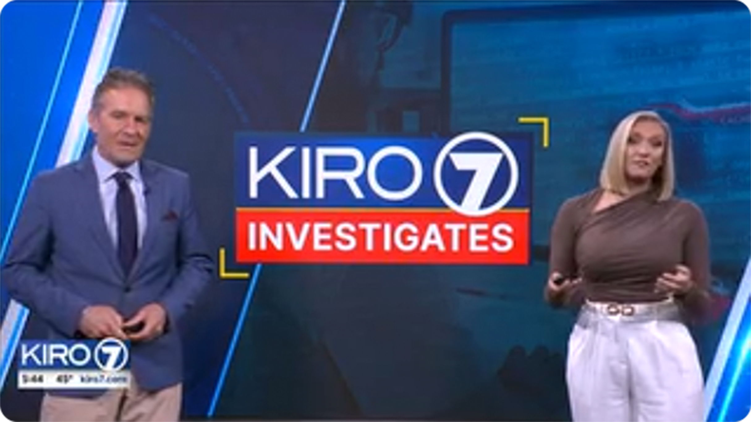 Two news anchors in studio beside screen displaying KIRO 7 Investigates logo during a television news segment.